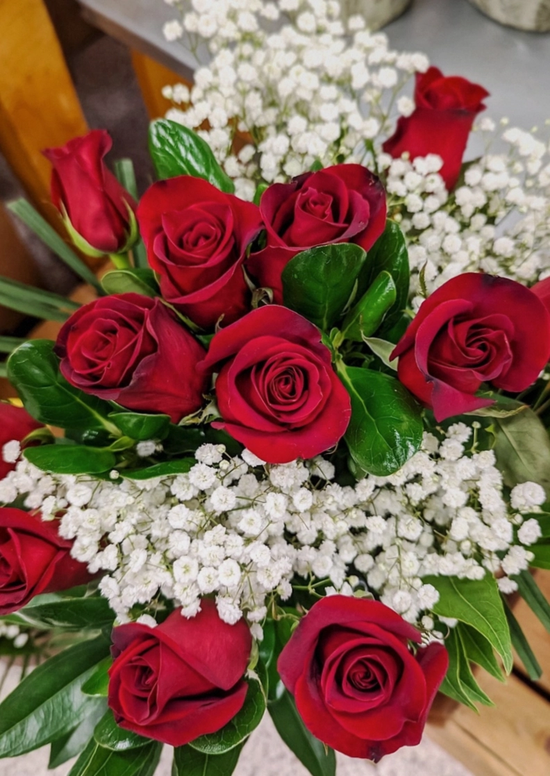 Tom, studio florist, wrapping a kraft paper bouquet